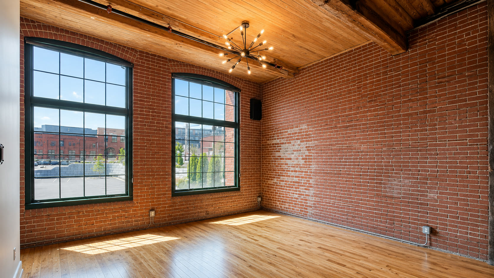 Loft interior with exposed brick and tall arched windows above the Blackstone