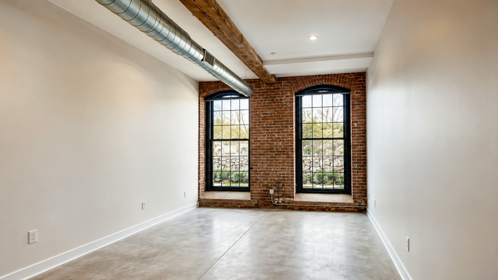 Restored mill bay with arched windows, morning light on polished concrete